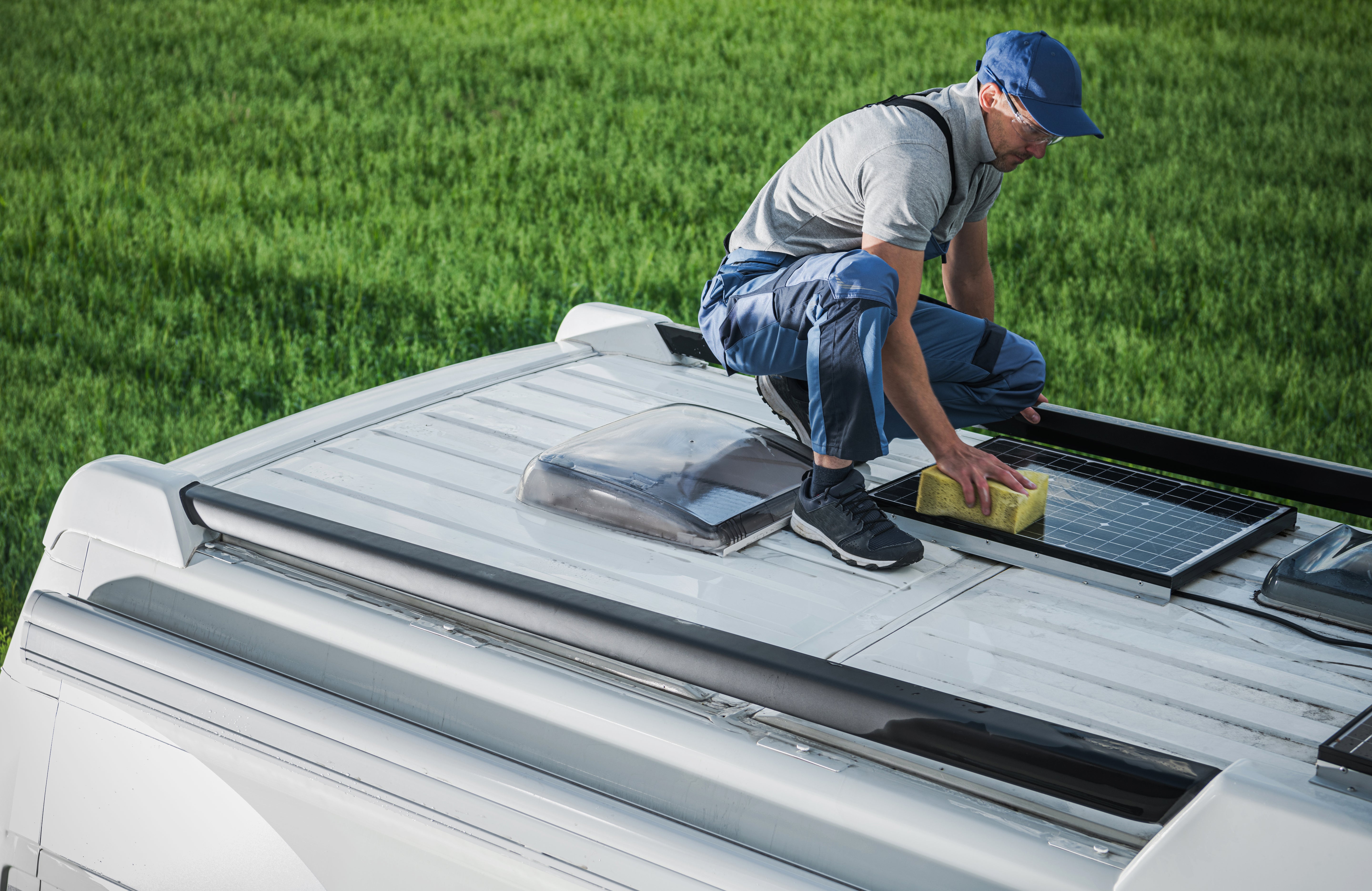 Solar panels mounted on a camper van roof getting serviced