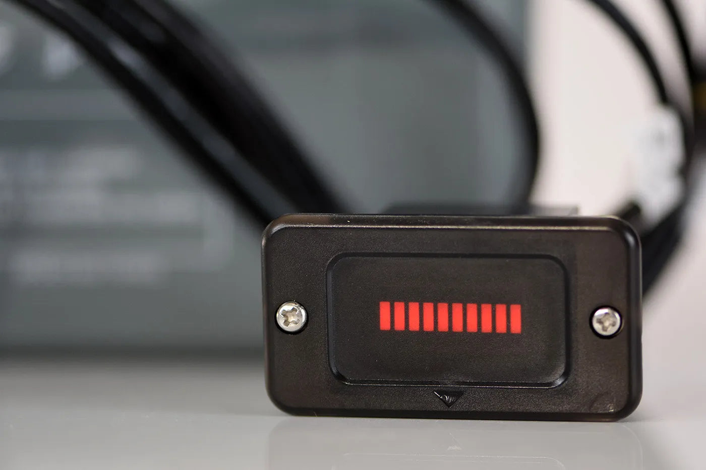 Small electronic device with red indicator lights on a blurred background