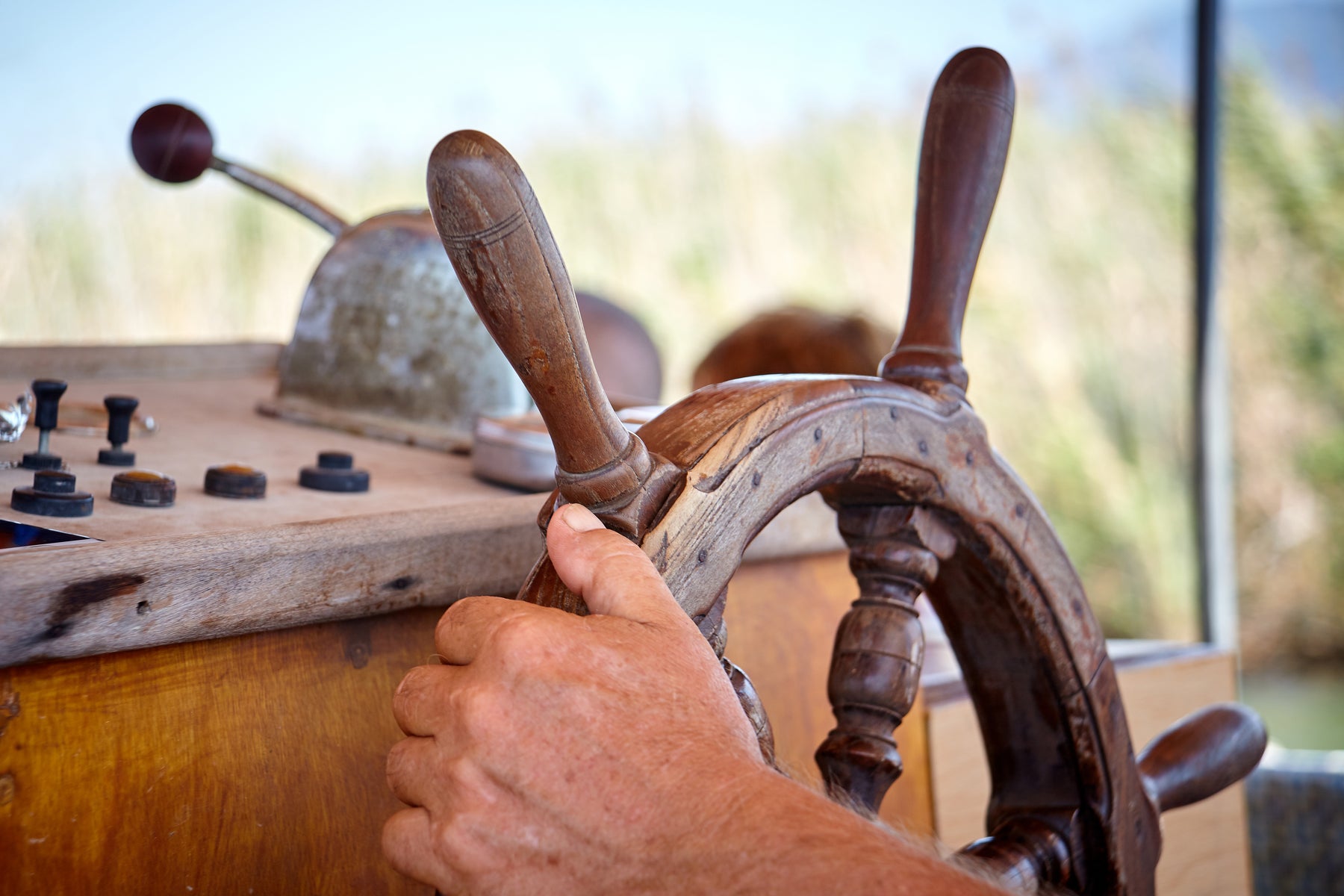 Close-up of a sailor's hand on a sailboat steering wheel