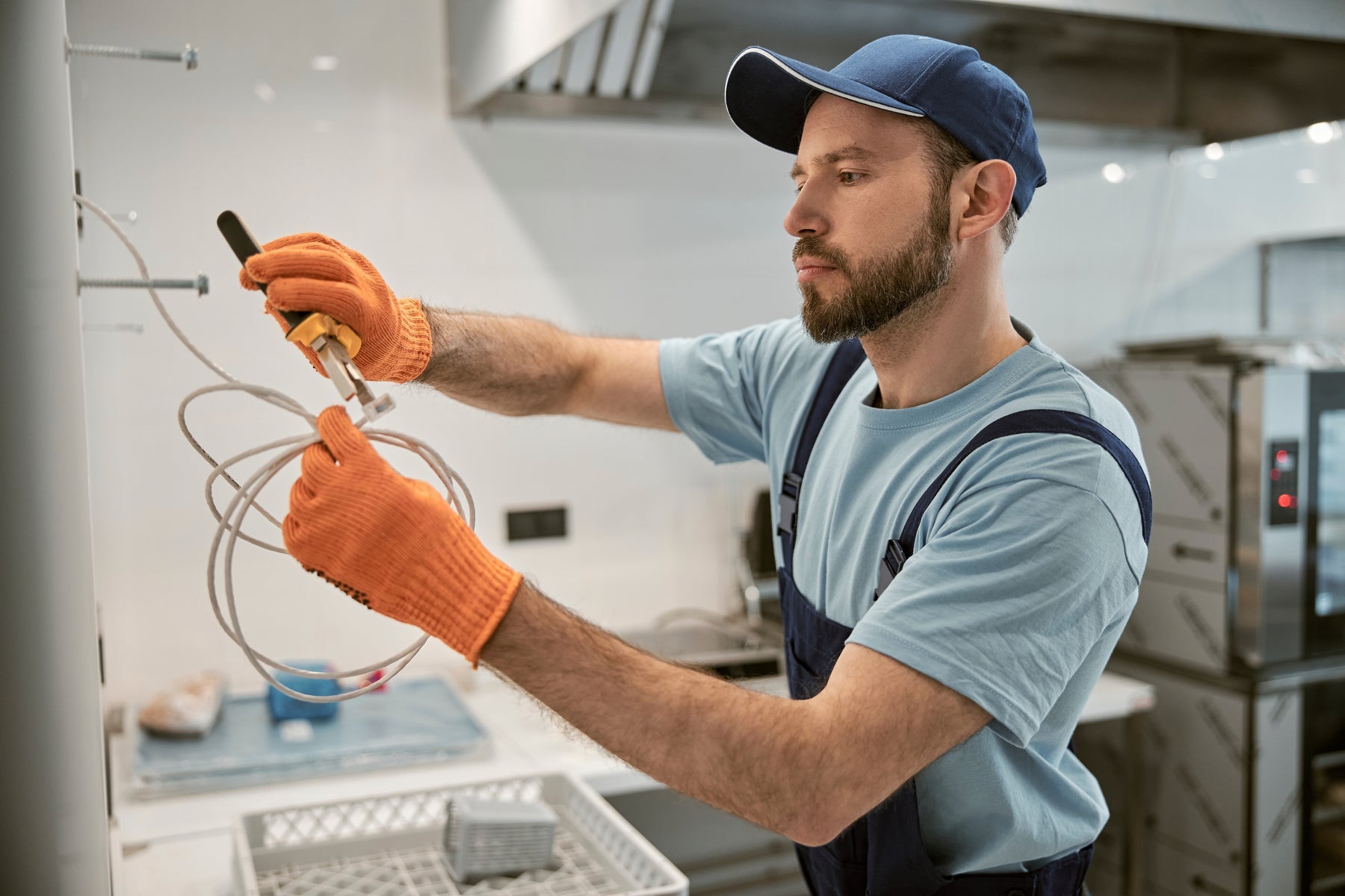 Certified electrician repairing electrical cable with insulated pliers