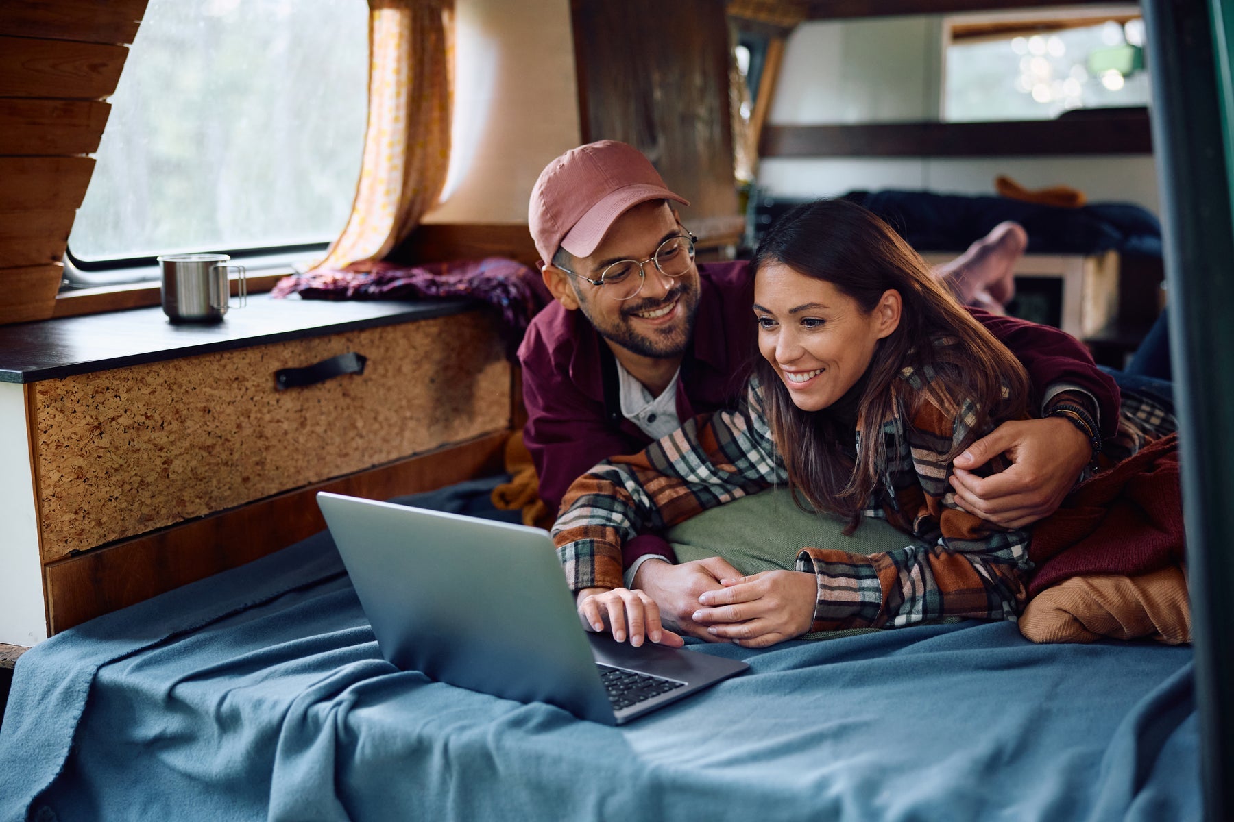 Couple using a laptop off grid inside their camper van
