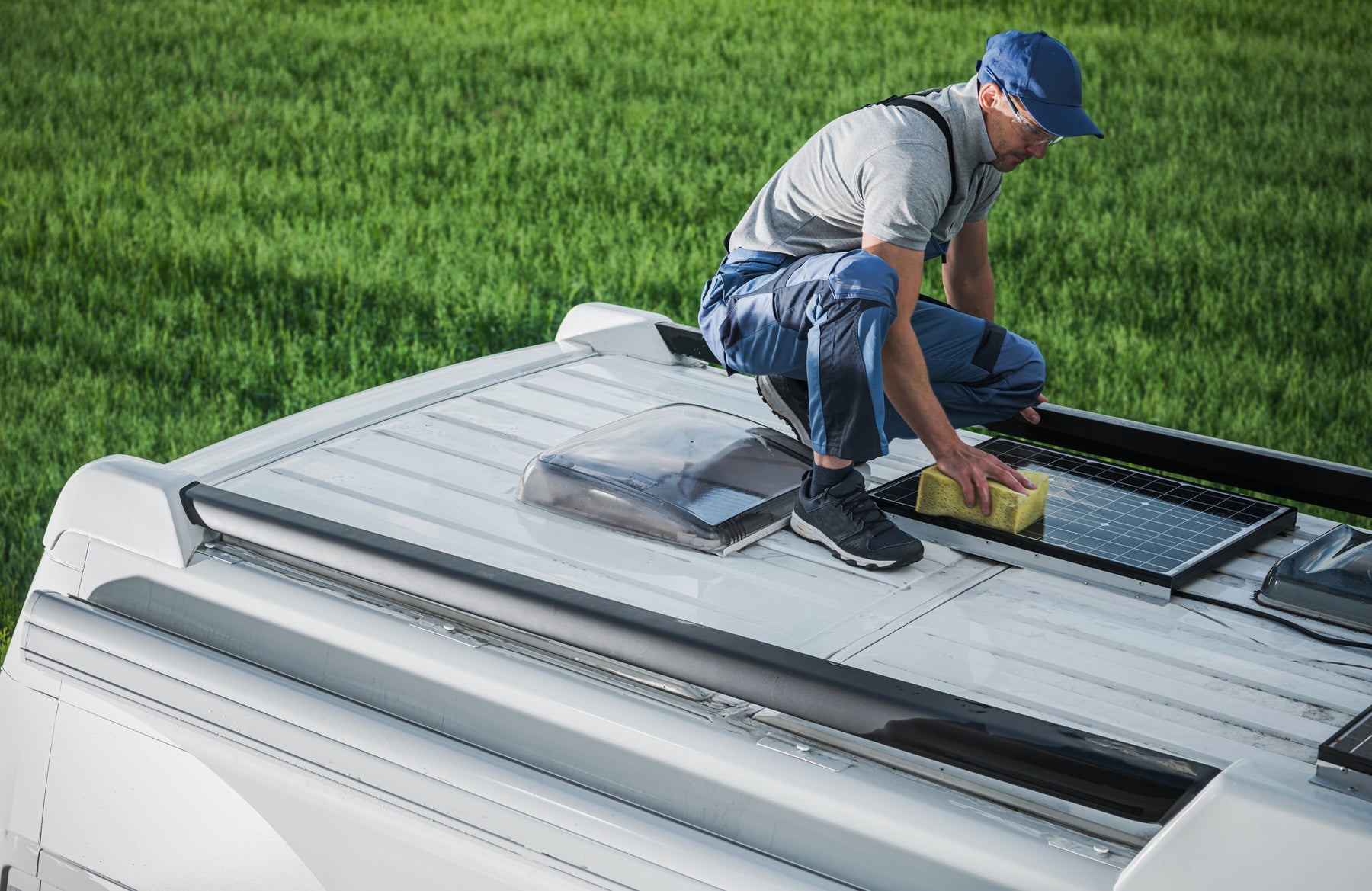Solar panels mounted on a camper van roof getting serviced